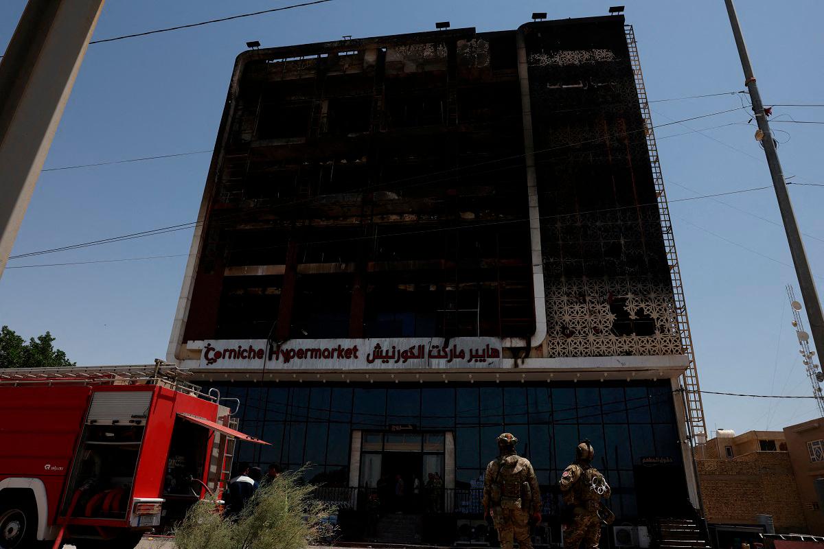 A fire truck stands next to the wreckage of a five-storey shopping center, after a massive overnight fire killed dozens of people, in al-Kut, Wasit province, Iraq, July 17, 2025. - REUTERS/Ahmed Saad