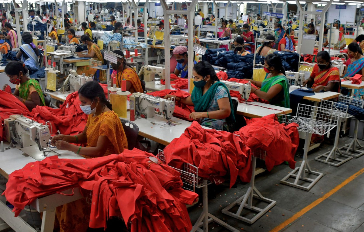 Garment workers stitch shirts at a textile factory of Texport Industries in Hindupur town in the southern state of Andhra Pradesh, India, February 9, 2022. - REUTERS