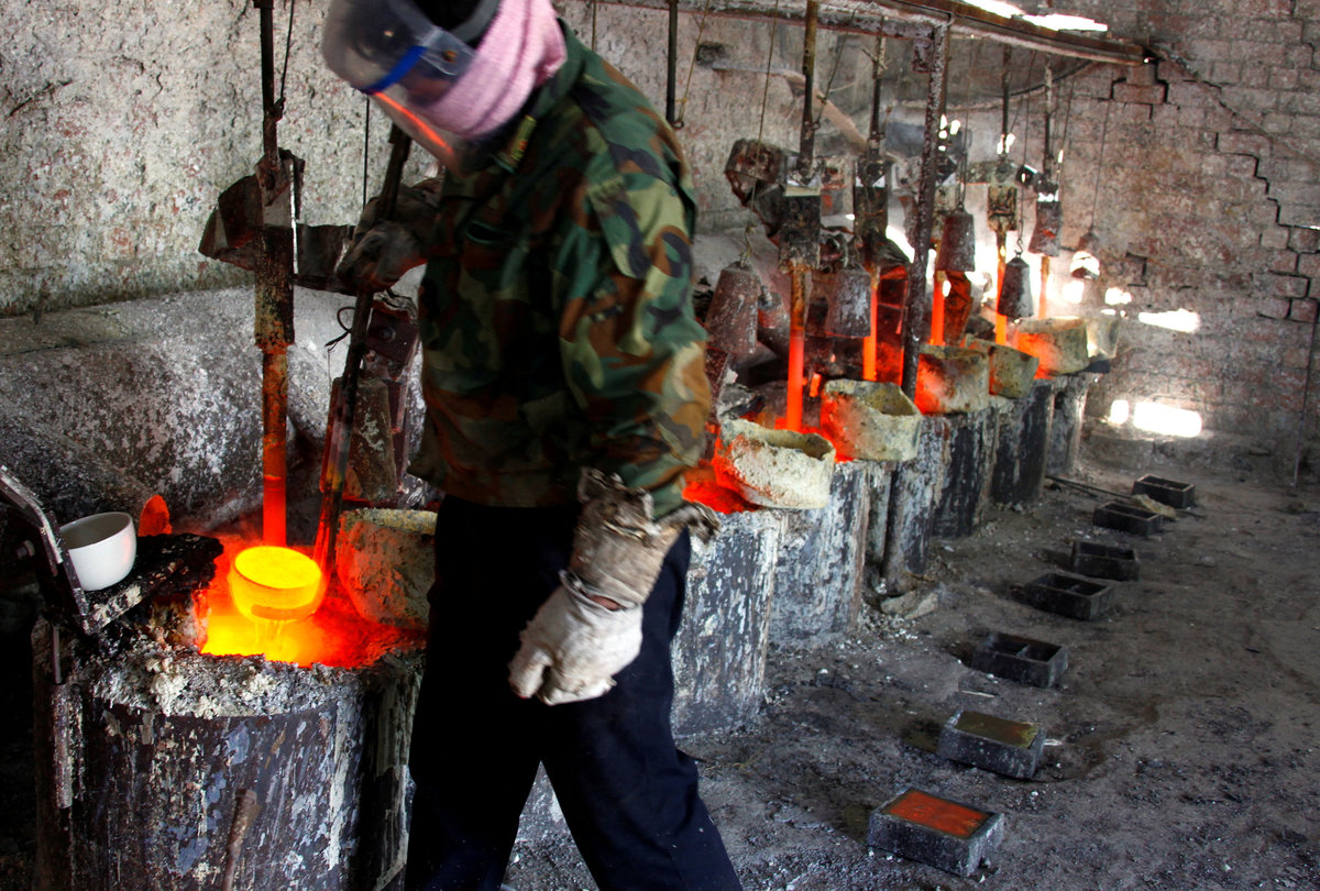 Ren Limin, a worker at the Jinyuan Company's smelting workshop, prepares to pour the rare earth metal Lanthanum into a mould near the town of Damao in China's Inner Mongolia Autonomous Region October 31, 2010. - REUTERS