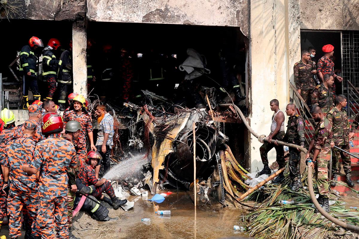 Firefighters and army members work next to the wreckage of an air force training aircraft after it crashed into Milestone College campus, in Dhaka, Bangladesh, July 21, 2025. - REUTERS/Stringer