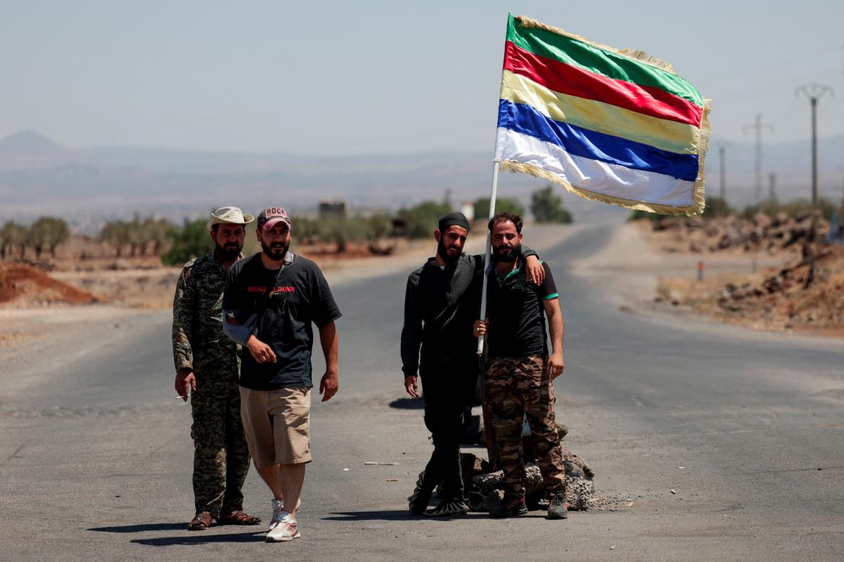 People hold a Druze flag, following deadly clashes between Druze fighters, Sunni Bedouin tribes and government forces, in Syria's predominantly Druze city of Sweida, Syria July 25, 2025. - REUTERSPIX