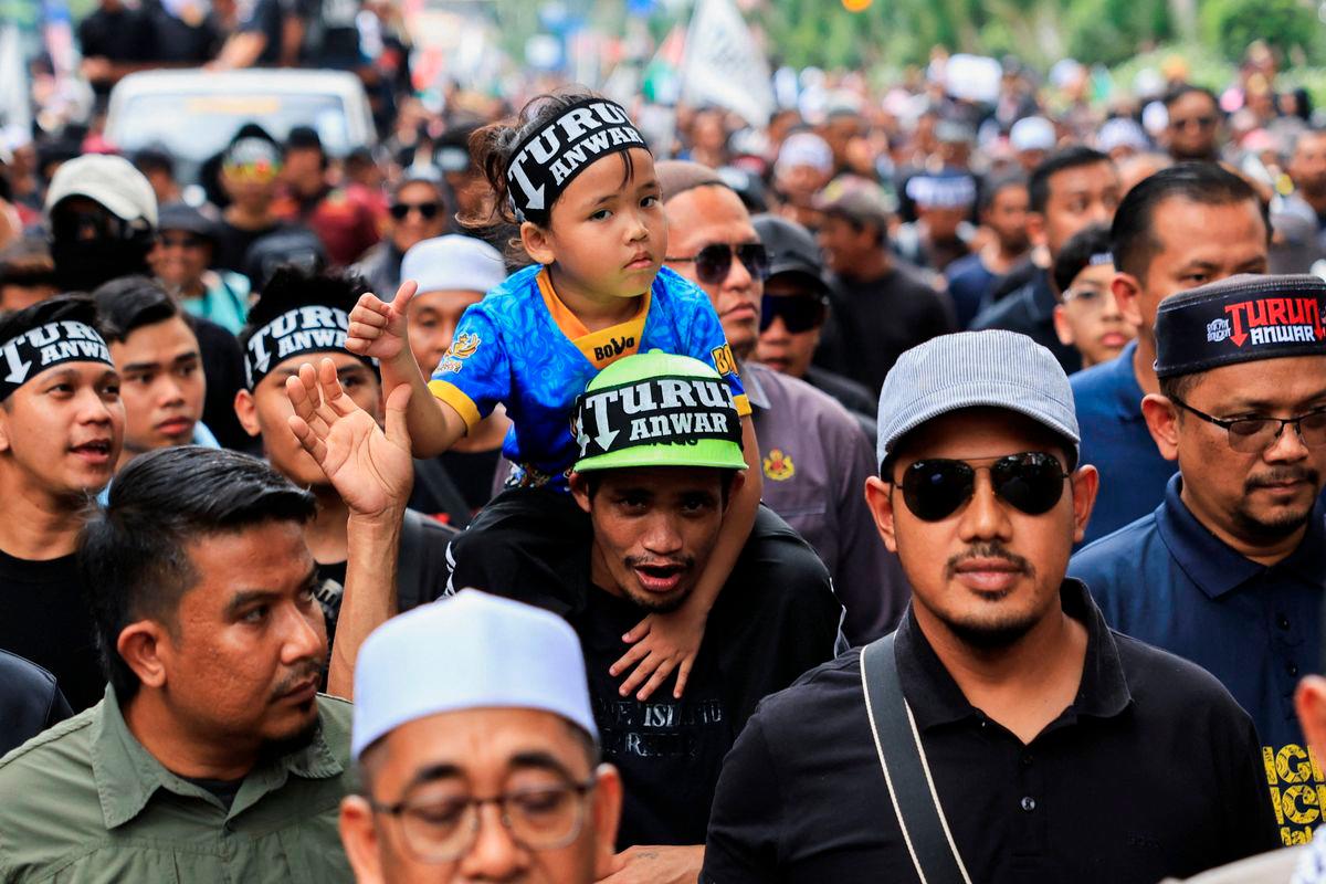 People wearing headbands with the slogan ‘TURUN ANWAR’, which means ‘Step down, Anwar’, march during a protest calling for Malaysian Prime Minister Anwar Ibrahim to resign in Kuala Lumpur, Malaysia July 26, 2025. REUTERS/Hasnoor Hussain