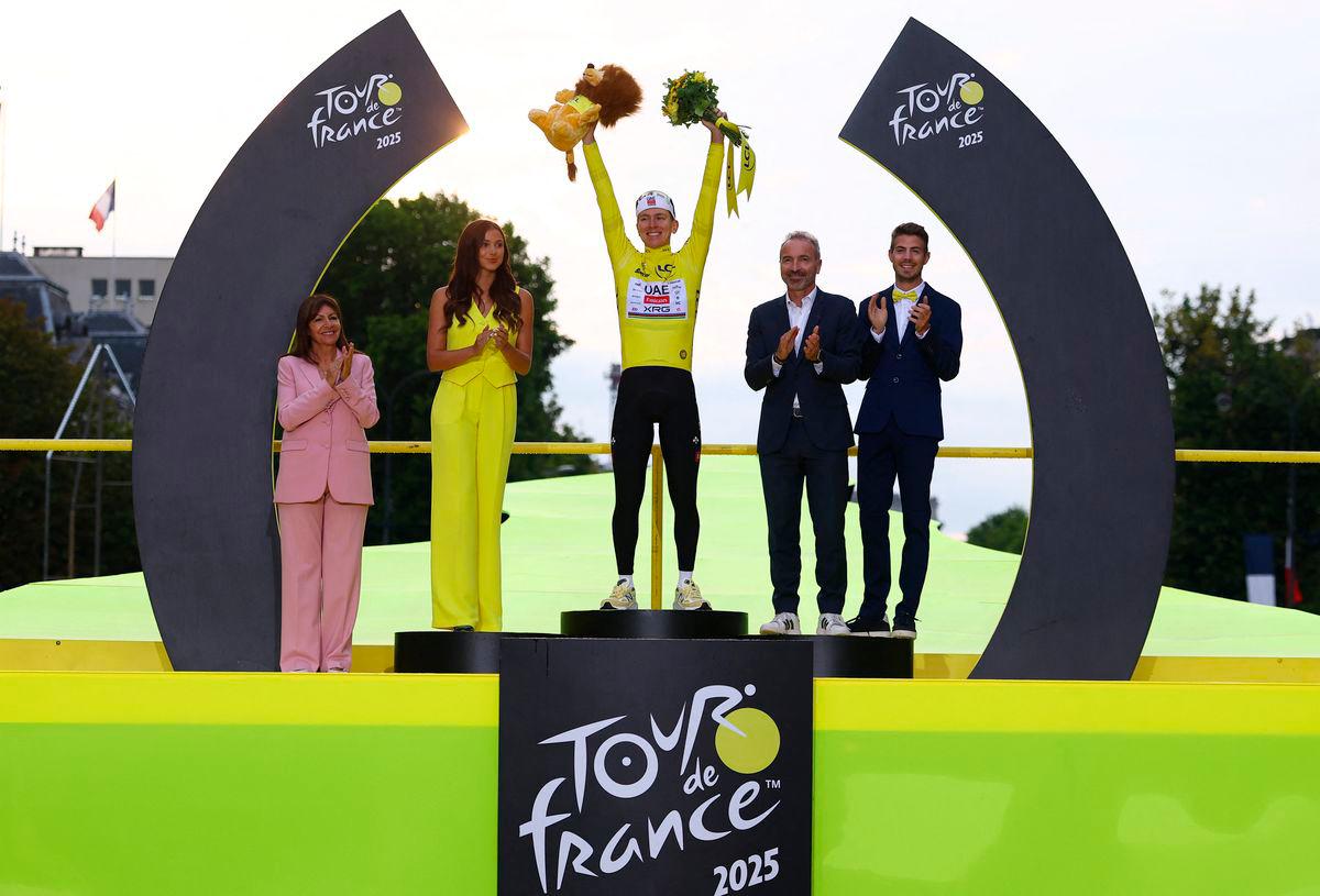 UAE Team Emirates XRG’s Tadej Pogacar celebrates on the podium wearing the yellow jersey after winning the Tour de France, as Paris’ mayor Anne Hidalgo applauds - REUTERS