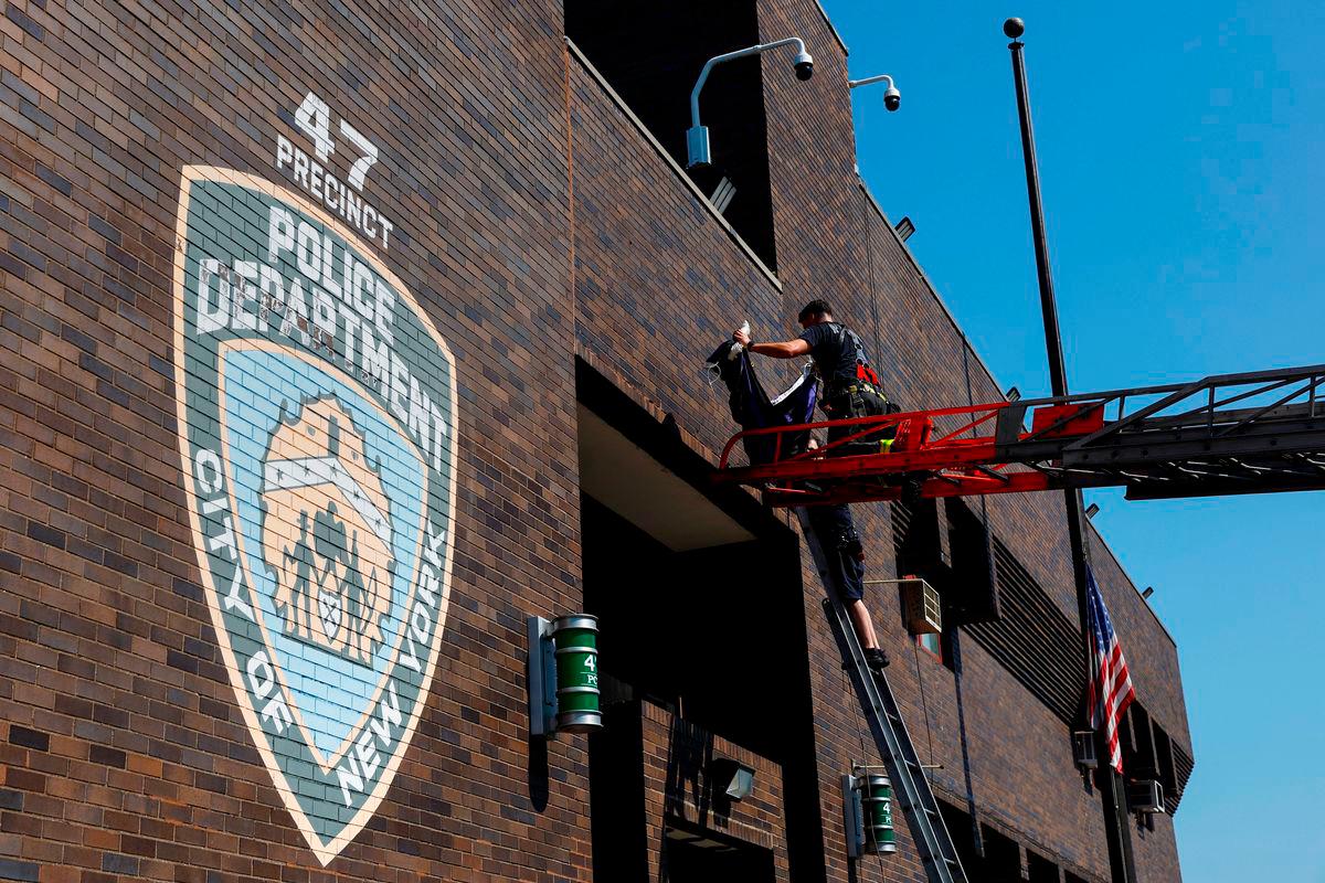 Members of the FDNY place a bunting outside the 47th precinct, which was the police station for the New York Police Department’s Didarul Islam who was killed in the deadly mass shooting, honoring him at the precinct in the Bronx borough of New York City - Reuterspix