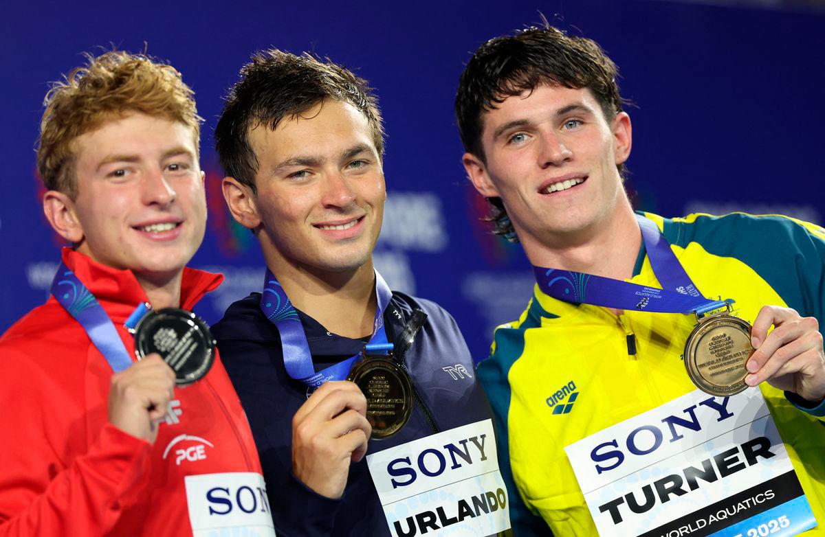 Gold medallist Luca Urlando of the U.S. celebrates on the podium during the medal ceremony with silver medallist Poland’s Krzysztof Chmielewski and bronze medallist Australia’s Harrison Turner - REUTERS