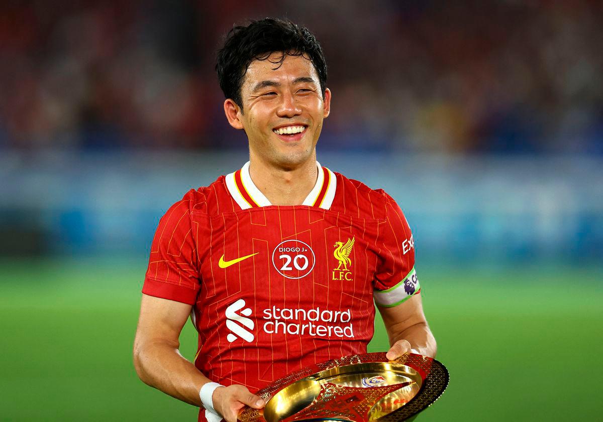 Liverpool’s Wataru Endo is presented with an award after the match - REUTERS