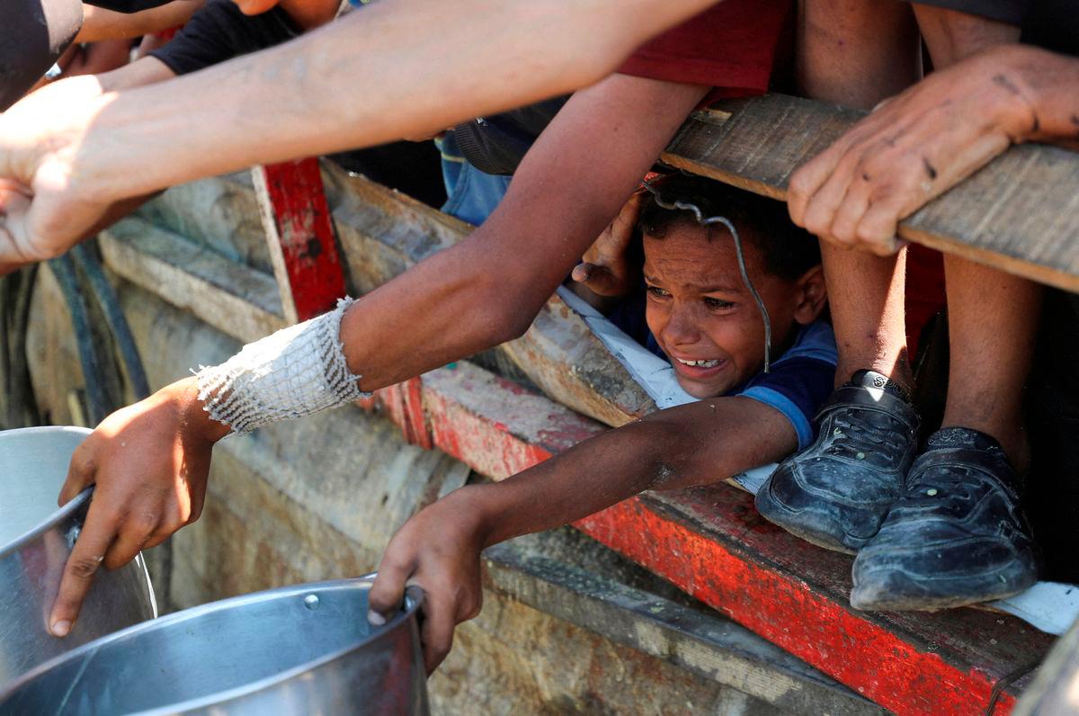 A Palestinian child waits to receive food from a charity kitchen, amid a hunger crisis, in Gaza City. Reuters/TPX Images of the Day