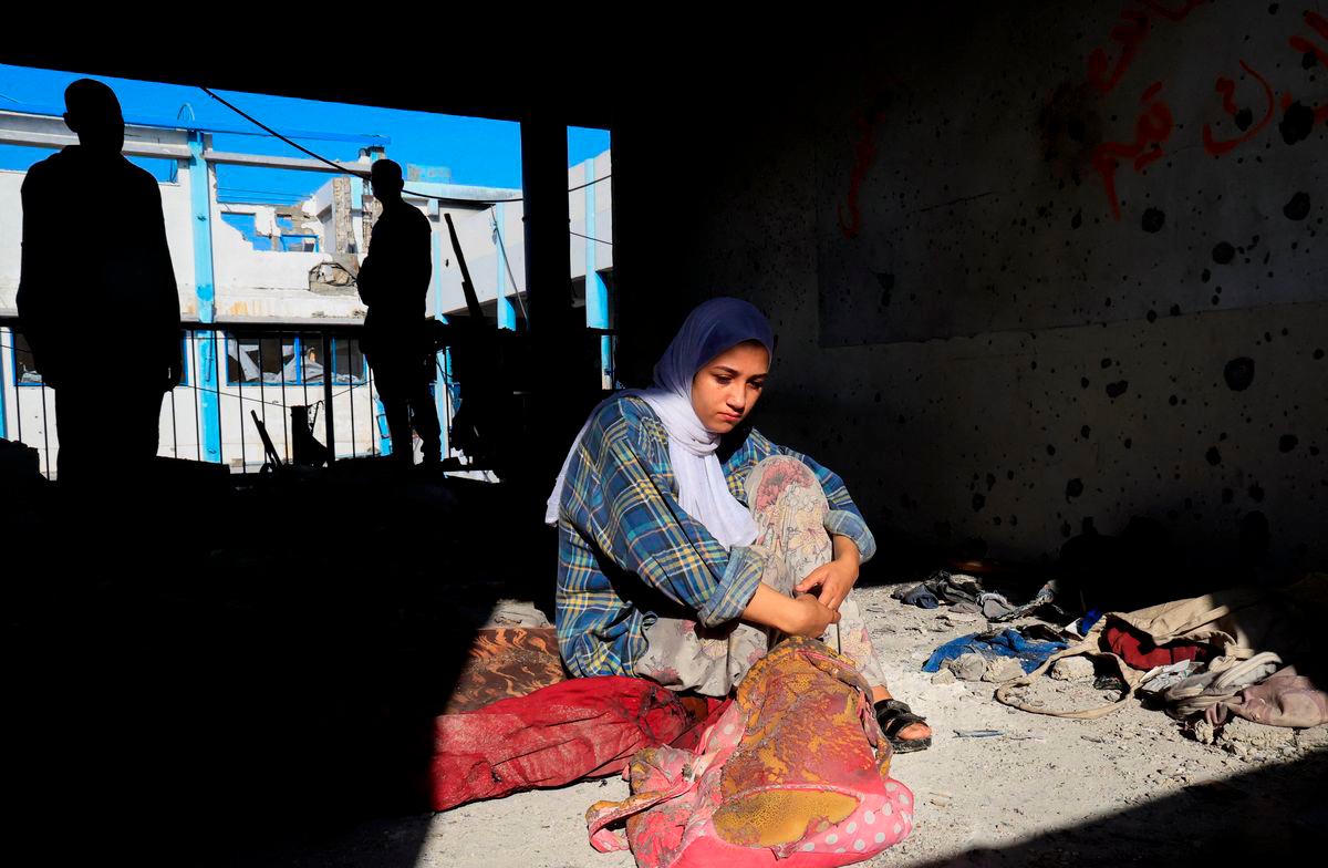 Hala Al-Masri, 17, sits at the site of an overnight Israeli strike on an UNRWA school that was sheltering displaced people, in Khan Younis, southern Gaza Strip, August 3, 2025. REUTERS/Hatem Khaled TPX IMAGES OF THE DAY