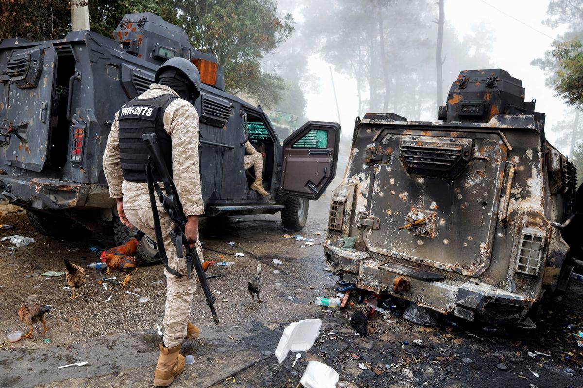 Police officers pass a burnt police armoured personnel carrier after gunmen kidnapped several people from an orphanage in a mountainous community that has been under deadly attacks by armed gangs since the start of this year, on the outskirts of Port-au-Prince, in Kenscoff. Reuterspix