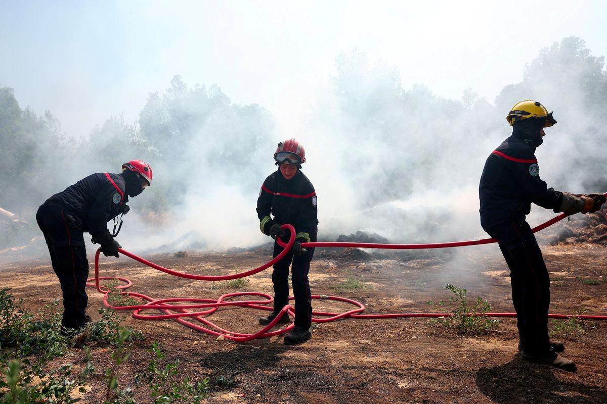 Firefighters hold a hose as they battle a wildfire near Saint-Laurent-de-la-Cabrerisse, southern France, August 7, 2025. - REUTERSPIX