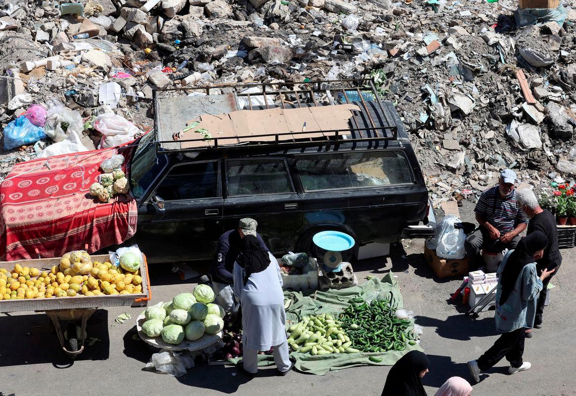 A woman buys vegetables from a vendor at Nabatieh market that reopened after it was destroyed during the last war between Israel and Hezbollah, in Nabatieh, southern Lebanon May 19, 2025. - REUTERSPIX