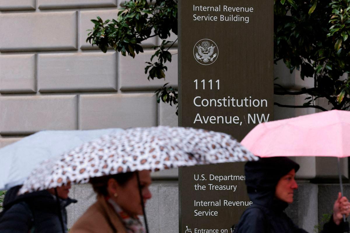 People walk in the rain past the Internal Revenue Service (IRS) building in Washington, D.C. Reuterspix