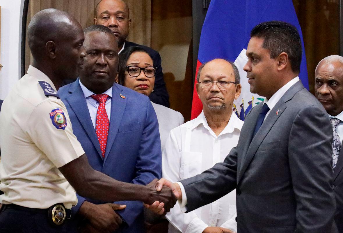 Haiti’s former National Palace Security Chief Vladimir Paraison shakes hands with President of Haiti’s Transitional Presidential Council (CPT) Laurent Saint-Cyr, after being officially named National Police Chief. Reuterspix