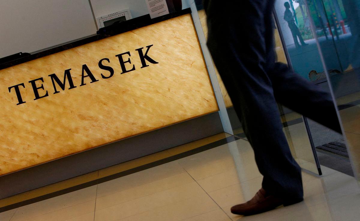 FILE PHOTO: A man passes a logo of state investor Temasek Holdings at their office in Singapore July 8, 2014. REUTERS/Edgar Su/File Photo/File Photo