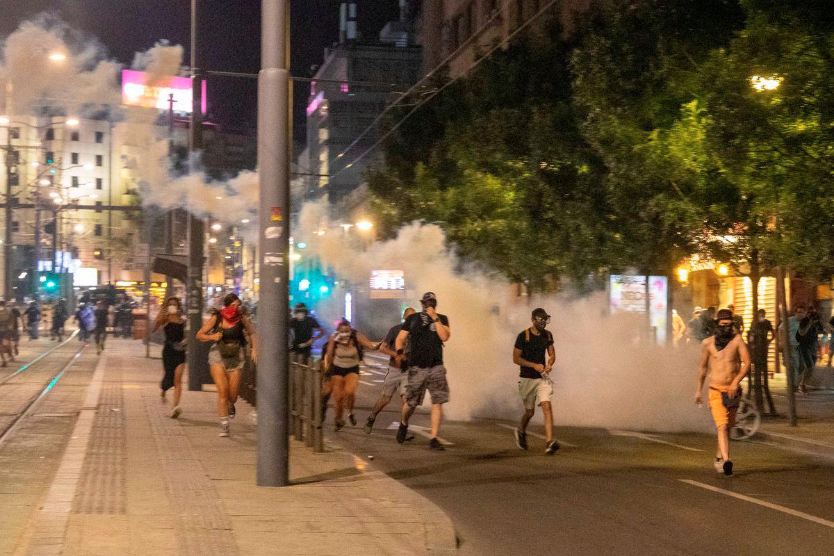 Anti-government protesters walk through tear gas during clashes with police in Belgrade, Serbia, August 15, 2025. - REUTERS