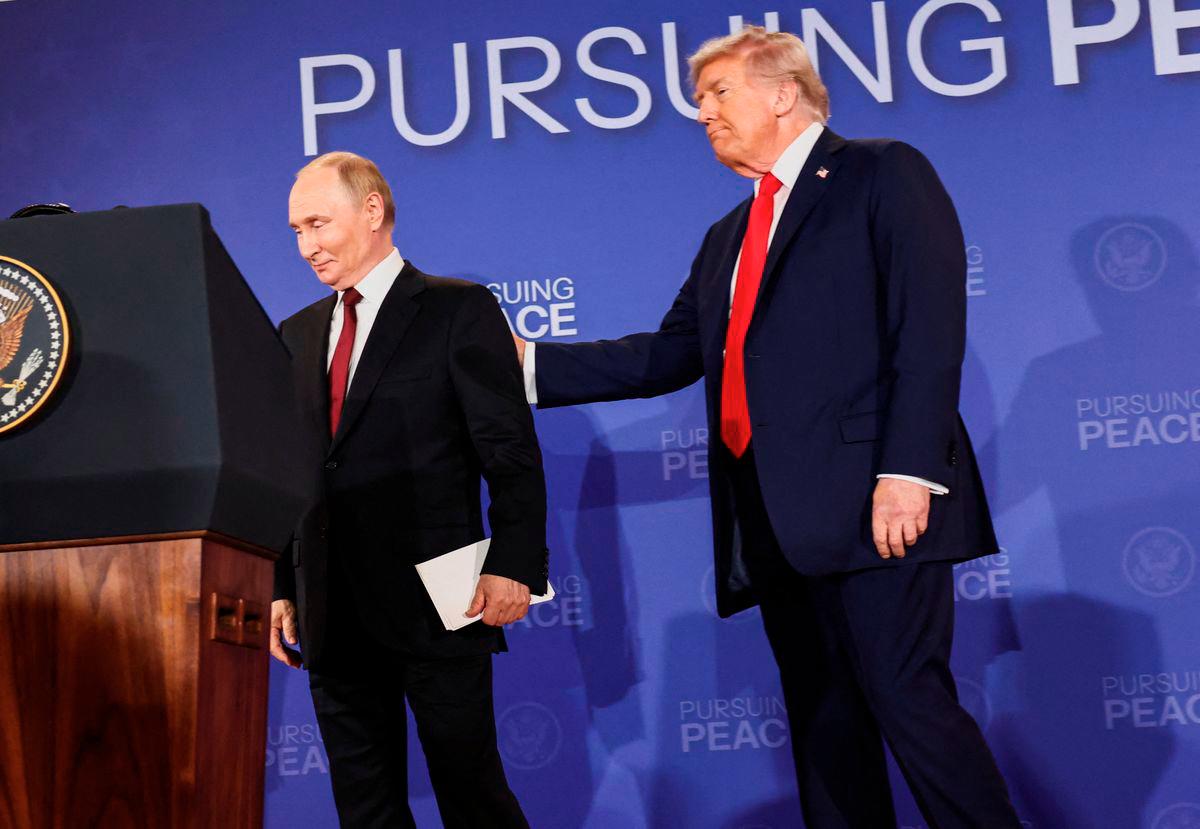 U.S. President Donald Trump holds Russian President Vladimir Putin during a press conference following their meeting to negotiate an end to the war in Ukraine, at Joint Base Elmendorf-Richardson, in Anchorage, Alaska, U.S., August 15, 2025. - REUTERS