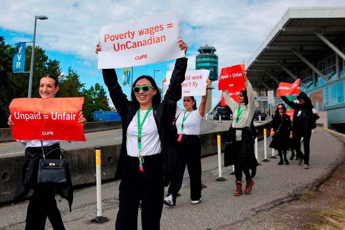 Demonstrators hold placards on the day the strike begins, after the union representing more than 10,000 of Air Canada’s flight attendants failed to reach an agreement with the airline, at Vancouver International Airport in Richmond, British Columbia, Canada, August 16, 2025. REUTERS/Chris Helgren