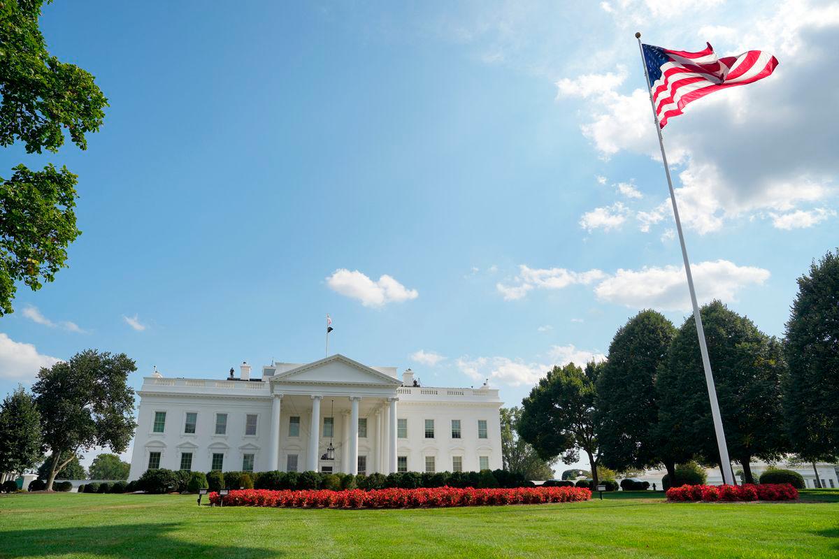 The U.S. flag flutters as people demonstrate in front of the White House after U.S. President Donald Trump deployed National Guard and ordered an increased presence of federal law enforcement to assist in crime prevention, in Washington, D.C., U.S., August 16, 2025. REUTERS/Ken Cedeno