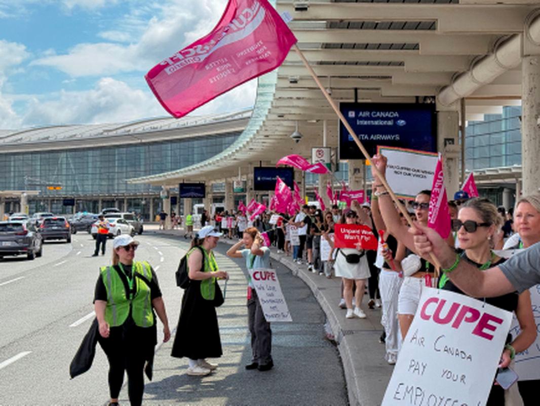 Demonstrators holds placards and flags, as Air Canada flight attendants said they will remain on strike and challenge a return-to-work order they called unconstitutional, defying a government decision to force them back to their duties, at Toronto Pearson International Airport in Mississauga, Ontario, Canada August 17, 2025. - REUTERSPIX