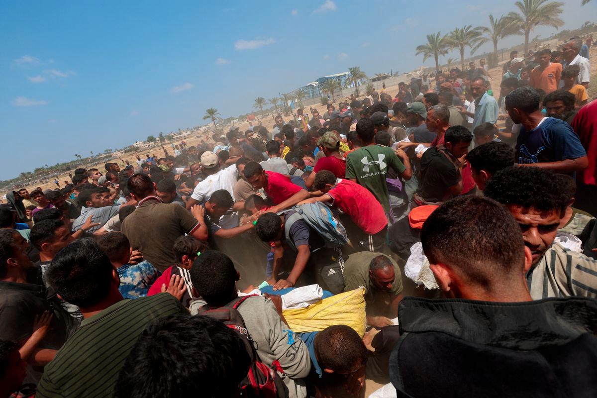Palestinians gather to receive aid packages, in Deir Al-Balah, in the central Gaza Strip August 18, 2025. - REUTERSPIX