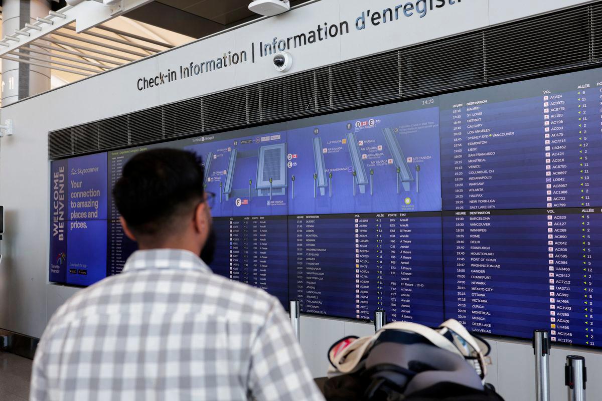 A stranded passenger looks at check-in information board as Air Canada flight attendants protest amid a standoff with a government board that said the stoppage was unlawful, at Toronto Pearson International Airport in Mississauga, Ontario, Canada August 18, 2025. - REUTERSPIX