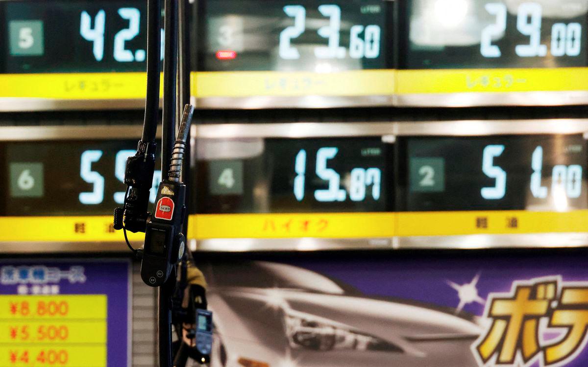 Gasoline fuel guns are pictured in front of fuel boards at a gasoline station in Tokyo, Japan September 20, 2022. - REUTERS