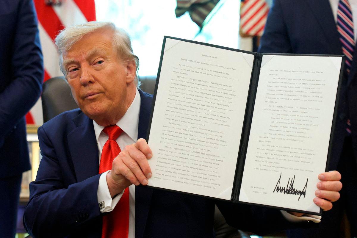 U.S. President Donald Trump holds up an executive order after signing it in the Oval Office at the White House in Washington, D.C. Reuterspix/TPX IMAGES OF THE DAY