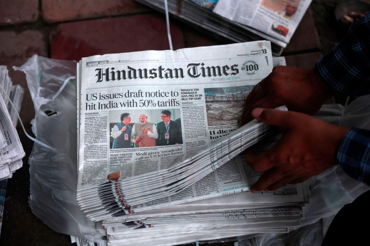 A hawker sorts copies of the latest edition of Hindustan Times, with the lead story on U.S. tariffs on most Indian goods, in New Delhi, India, August 27, 2025. - REUTERSPIX