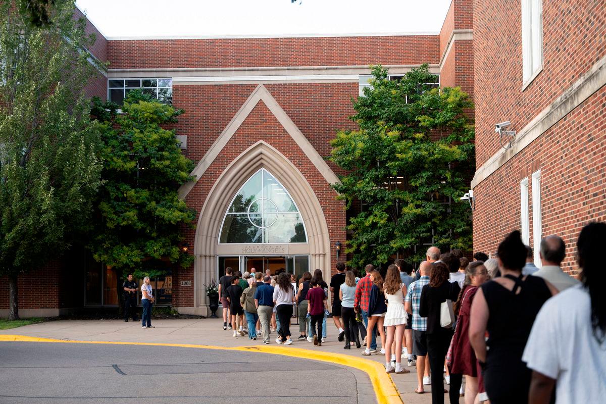 People line up to attend a prayer vigil at Academy of Holy Angels following a shooting earlier in the day at Annunciation Church in Minneapolis, in Richfield, Minnesota, U.S. August 27, 2025. REUTERS/Tim Evans