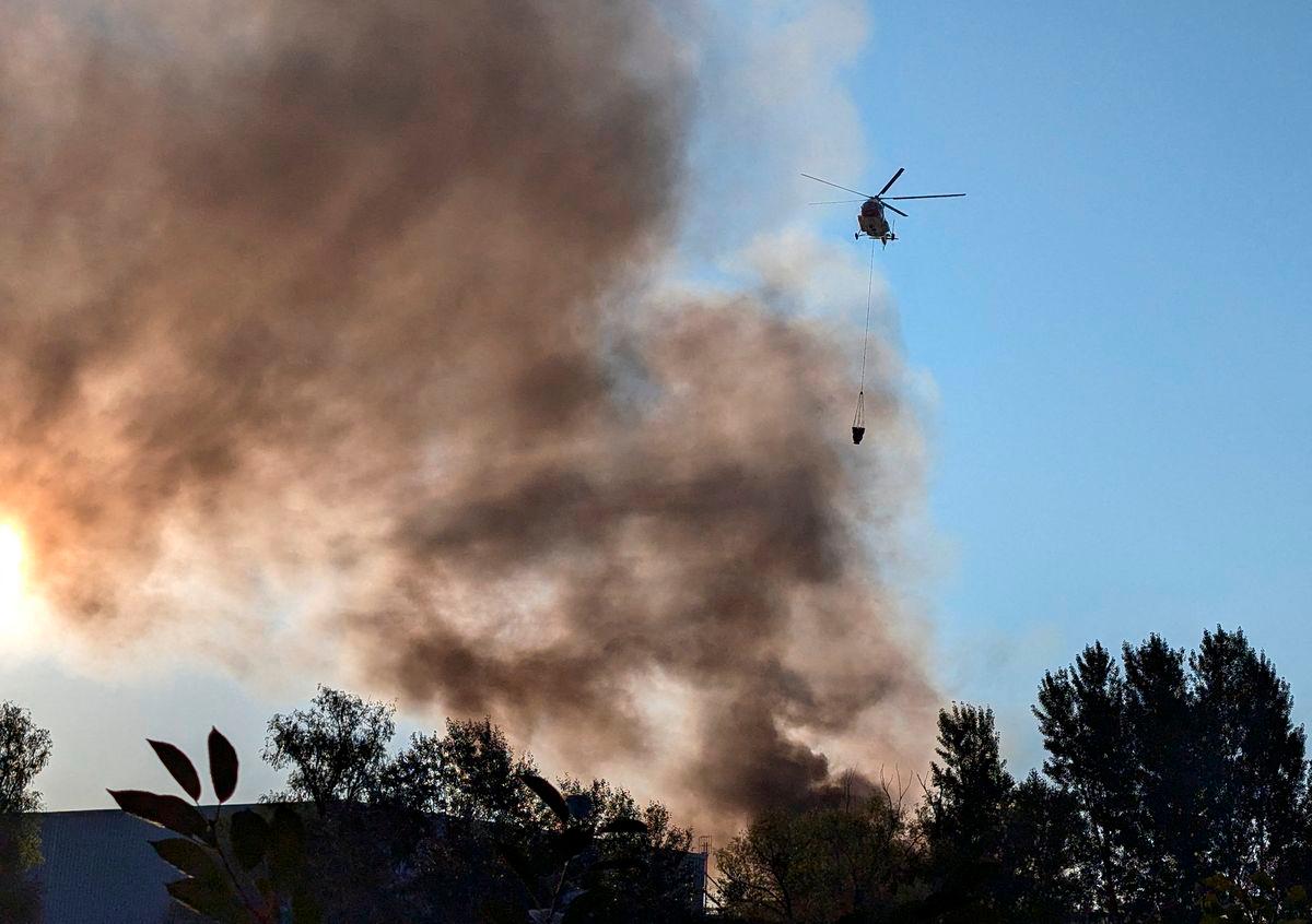 A fire-fighting helicopter collects water to control a fire after a Russian missile and drone strike, amid Russia’s attack on Ukraine, in Kyiv, Ukraine August 28, 2025. REUTERS/Stringer