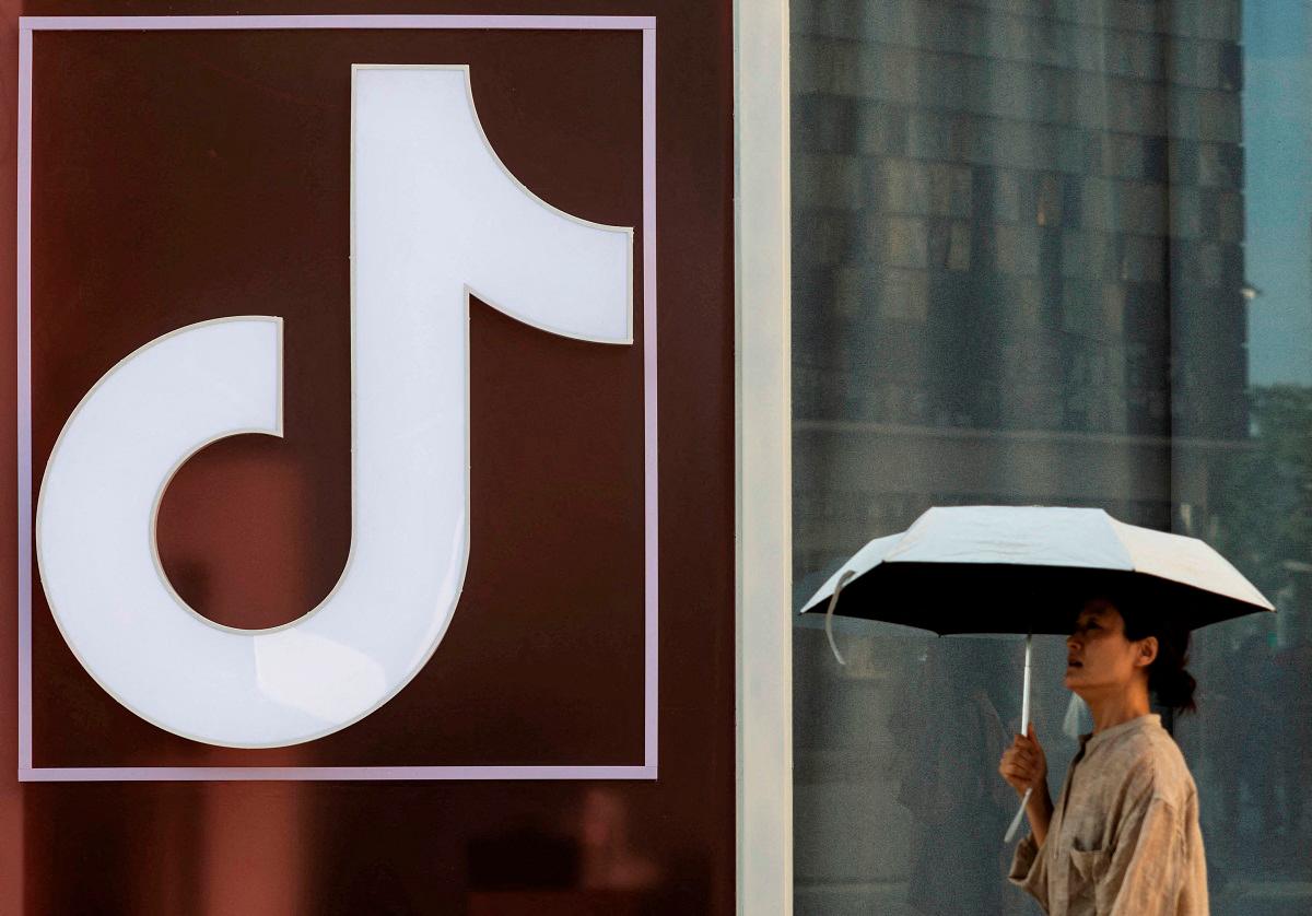 A woman walks past a logo of Tik Tok social network on Wangfujing street in Beijing, China - Reuters file pic