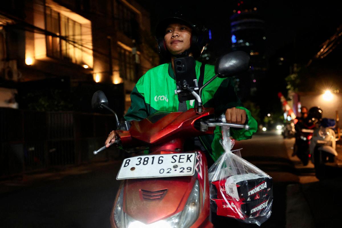 Pratiwi Ariyanti, 38, an Indonesian ride-hailing driver, rides her motorbike after picking up food ordered and donated by a customer from overseas through an app, in solidarity following the death of a ride-hailing driver and another injured in the widespread protests in Indonesia against government policies, in Jakarta, Indonesia, September 3, 2025. - REUTERSPIX