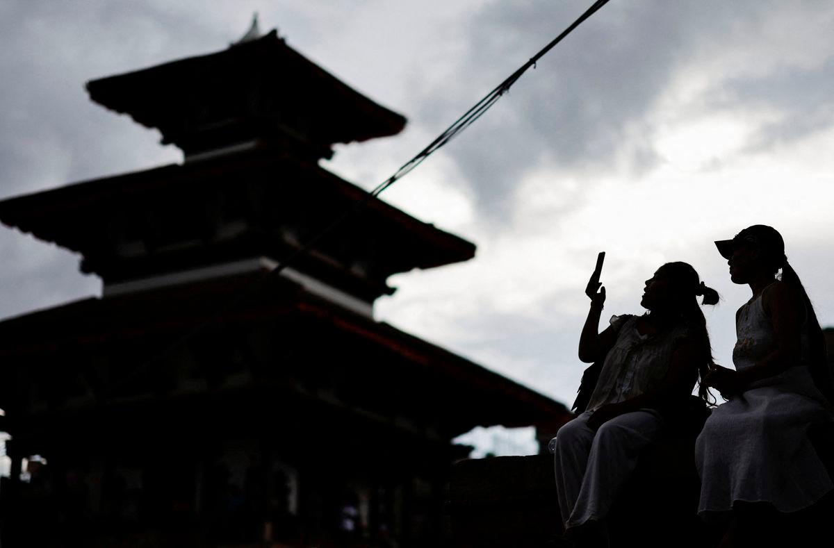 A woman uses her phone at Bashantapur Durbar Square after the government announced it will close all social media not registered with the government saying the move was aimed at managing and making the social media responsible, in Kathmandu, Nepal September 4, 2025. REUTERS/Navesh Chitrakar