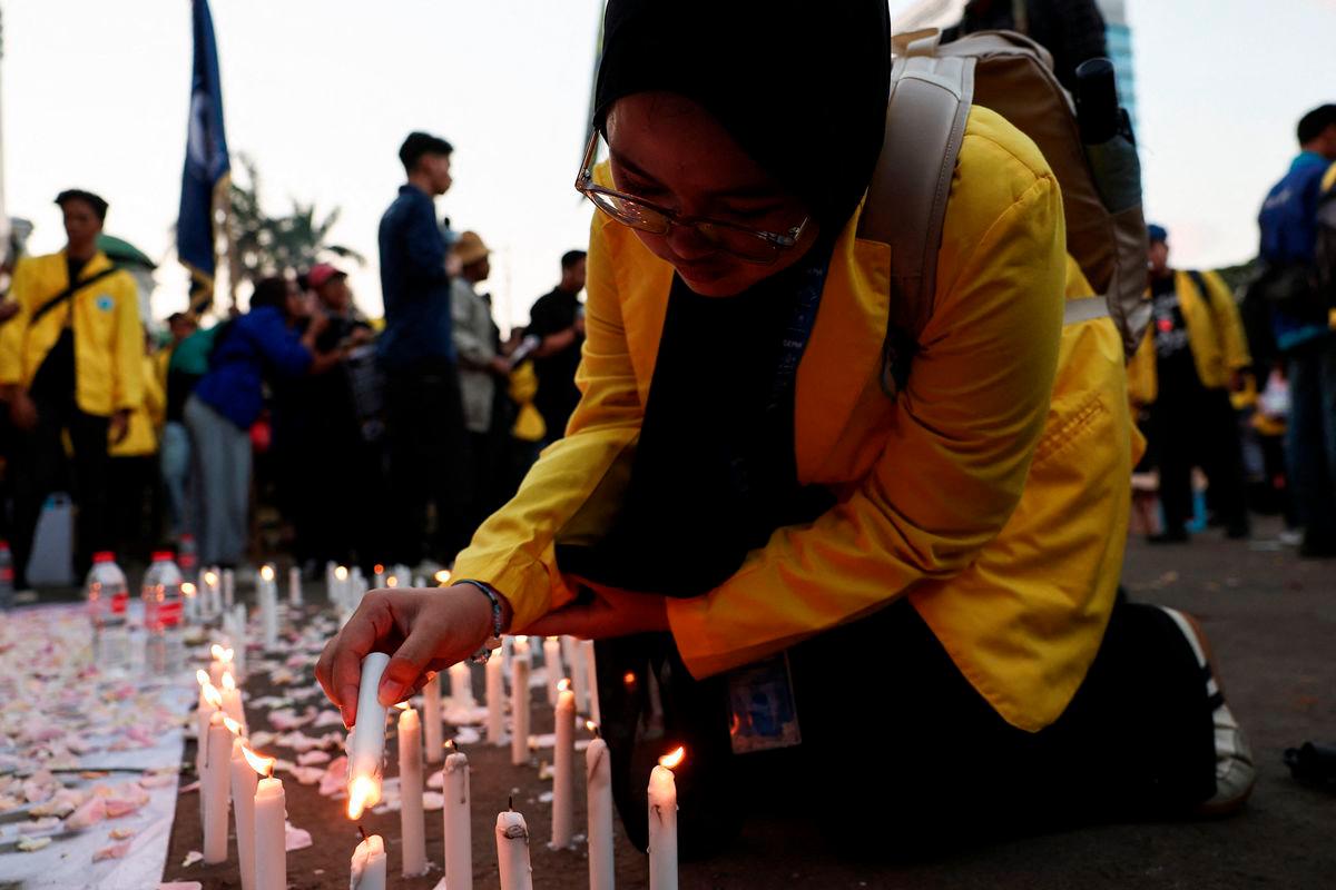 A university student lights candles to offer condolences for victims who were killed during widespread protests over parliamentarians’ extra pay and housing allowances, during a protest demanding the release of detained demonstrators, outside Indonesian parliament building in Jakarta, Indonesia September 4, 2025. REUTERS/Willy Kurniawan