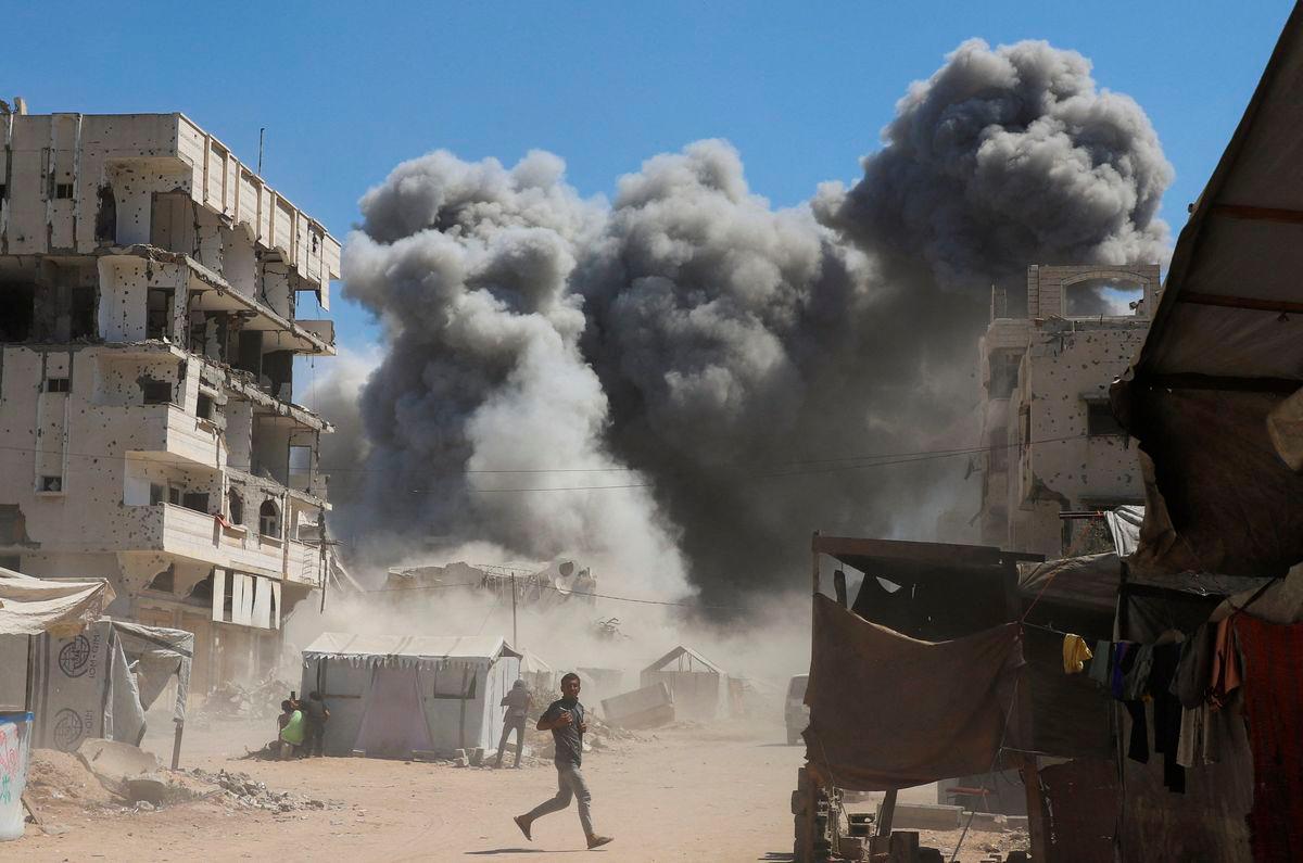 Smoke rises from an evacuated residential building which was housing displaced Palestinians, after it was hit by an Israeli air strike, in Gaza City, September 14, 2025. REUTERS/Ebrahim Hajjaj