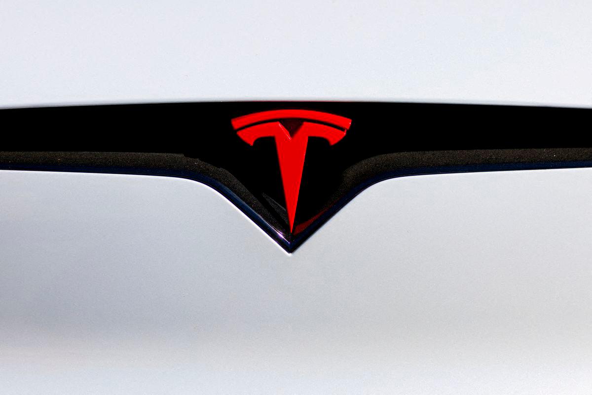 FILE PHOTO: A logo is pictured on an electric car at the Tesla Inc. vehicle facility in Costa Mesa, California, U.S., November 1, 2023. REUTERS/Mike Blake/File Photo