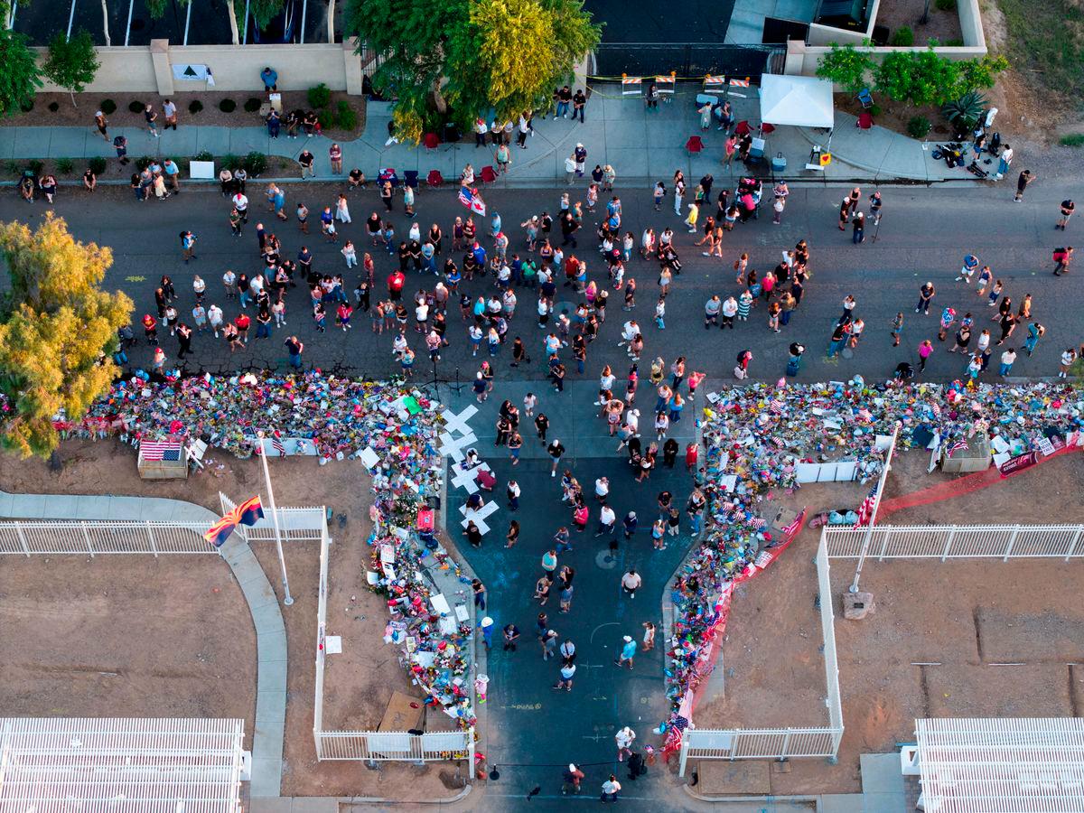 A drone view shows people gathering to pay tribute to slain conservative commentator Charlie Kirk at the headquarters of Turning Point USA, ahead of a memorial service for him which is to be held on September 21, in Phoenix, Arizona, U.S., September 20, 2025. REUTERS/Cheney Orr