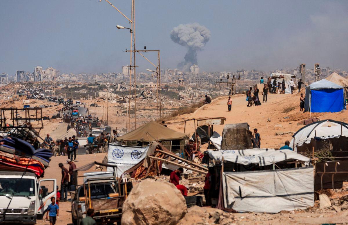 Smoke rises from an Israeli strike, as displaced Palestinians, fleeing northern Gaza due to an Israeli military operation, move southward after Israeli forces ordered residents of Gaza City to evacuate to the south, in the central Gaza Strip September 22, 2025. - REUTERSPIX