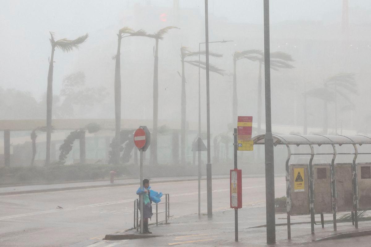 A woman clings to a traffic sign to maintain balance against strong winds from Super Typhoon Ragasa in Hong Kong, China. Reuters/TPX Images of the day
