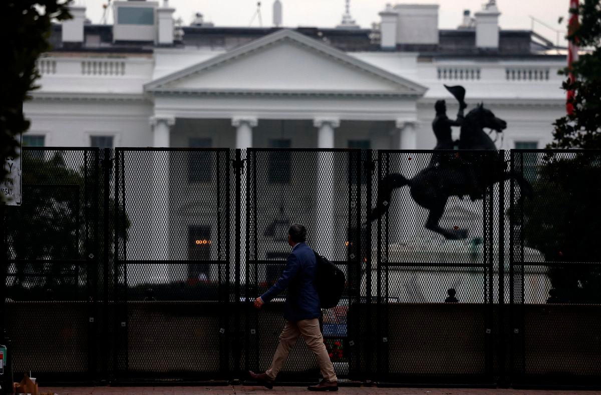 A man walks next to the anti-climb fence placed near the White House, in Washington, D.C. U.S., September 24, 2025. REUTERS/Daniel Becerril