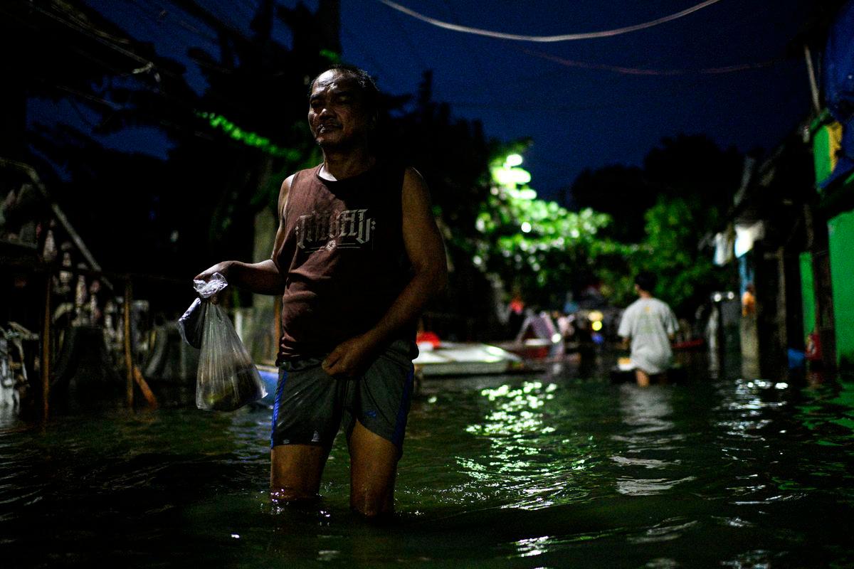 Seorang lelaki meredah jalan yang dibanjiri air selepas hujan lebat yang dipergiat oleh Ribut Tropika Kuat Bualoi, di Dela Paz, Binan, wilayah Laguna, Filipina, pada 26 September 2025. - Reuters