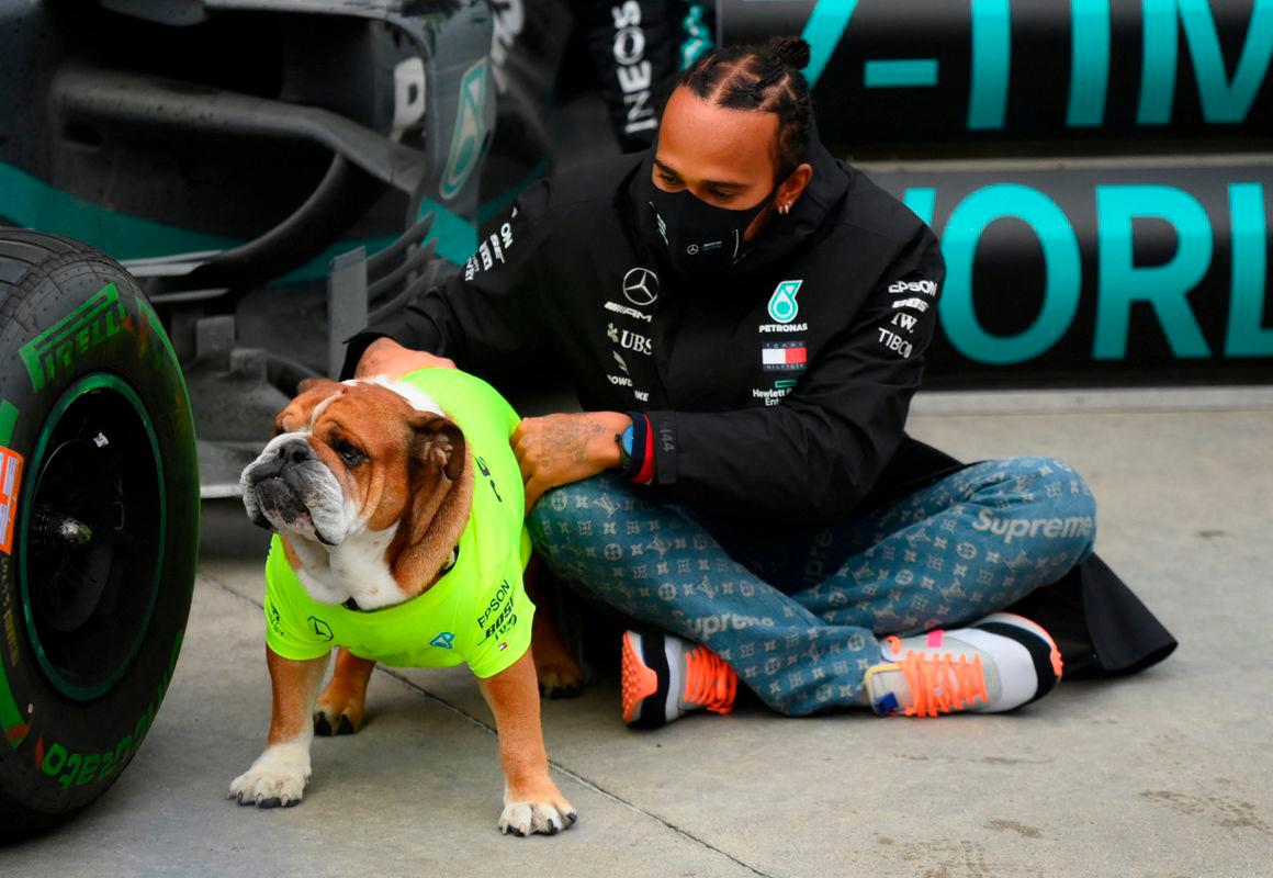 Mercedes’ Lewis Hamilton celebrates with his dog. Pool via Reuters