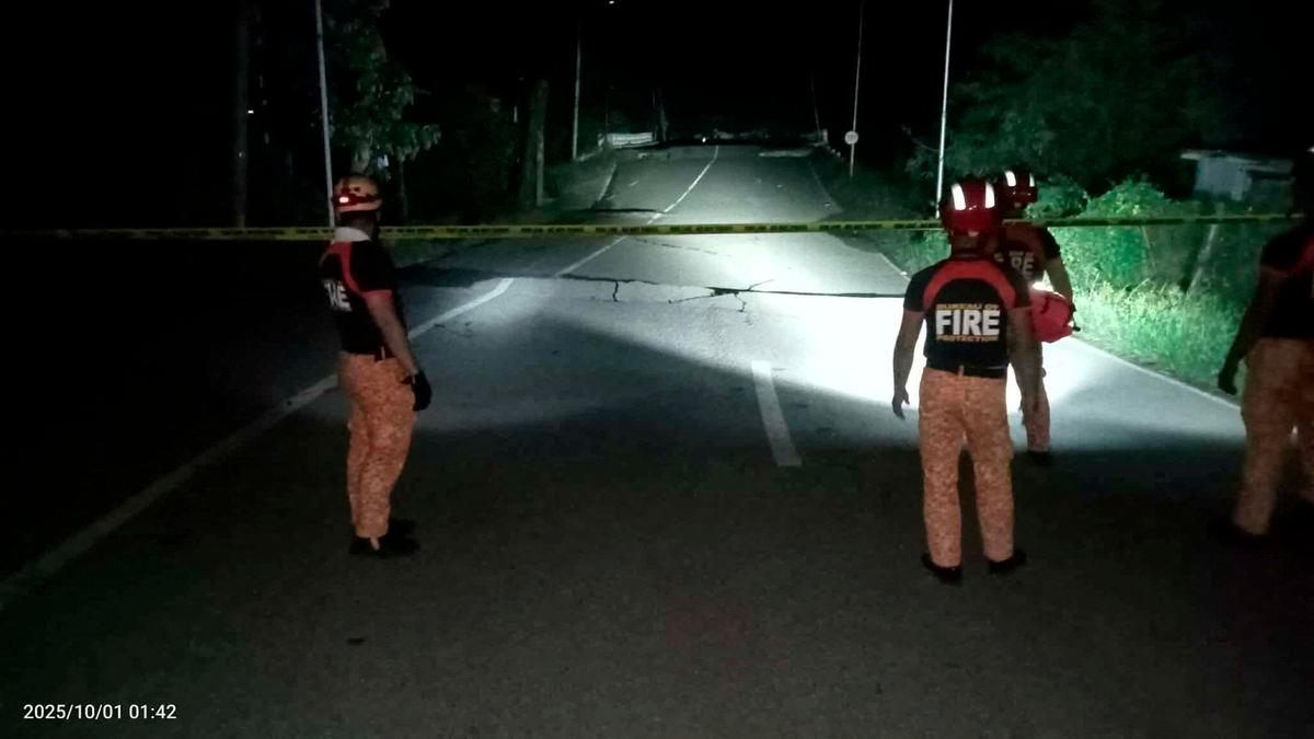 Rescue personnel stand in front of a crack in a road caused by a magnitude 6.9 quake, in Daanbantayan, Cebu Province, Philippines, October 1, 2025. - Municipality of Daanbantayan/Handout via REUTERSPIX