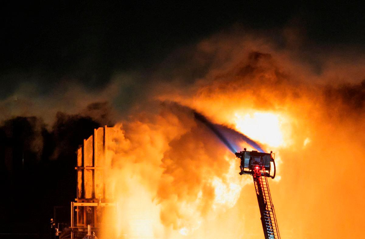 Hoses mounted on the ladder of a firefighting vehicle are used to contain a fire that broke out at the Chevron refinery, in El Segundo, California, U.S., October 2, 2025. REUTERS/Daniel Cole