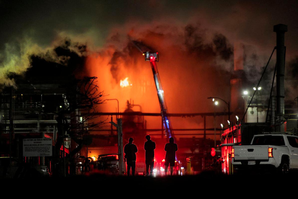 Orang ramai berdiri berhampiran loji penapisan Chevron, tempat berlakunya kebakaran besar, ketika pasukan bomba berusaha memadamkan api, di El Segundo, California, A.S., 3 Oktober 2025. - Reuters