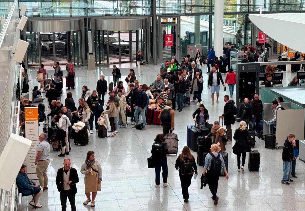 People line up at a service counter at the airport in Munich, after it was gradually resuming flights with delays expected through the day, hours after both runways were closed for the second time in less than 24 hours due to a drone sighting, in Munich, Germany, October 4, 2025. - REUTERSPIX
