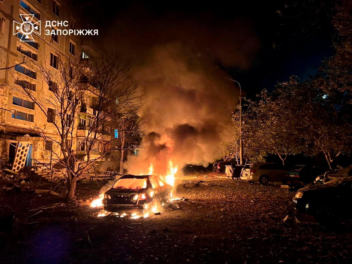 A car burns in front of an apartment building damaged during overnight Russian drone and air strikes, amid Russia’s attack on Ukraine, in Zaporizhzhia, Ukraine October 5, 2025. Press service of the State Emergency Service of Ukraine in Zaporizhzhia region/Handout via REUTERS