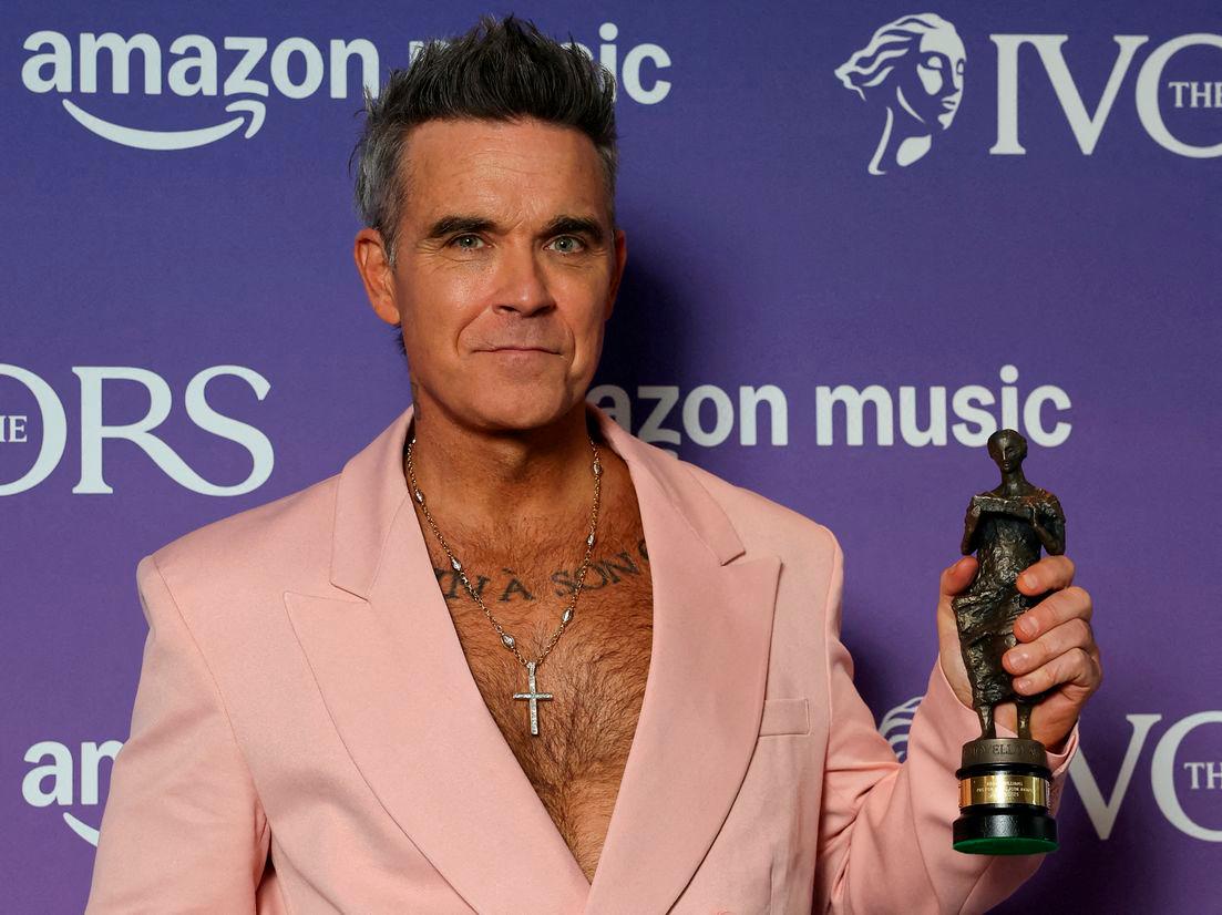 Robbie Williams poses for a portrait holding his Music Icon award at the Ivor Novello Awards in London, Britain, May 22, 2025. REUTERS/Toby Melville/File Photo
