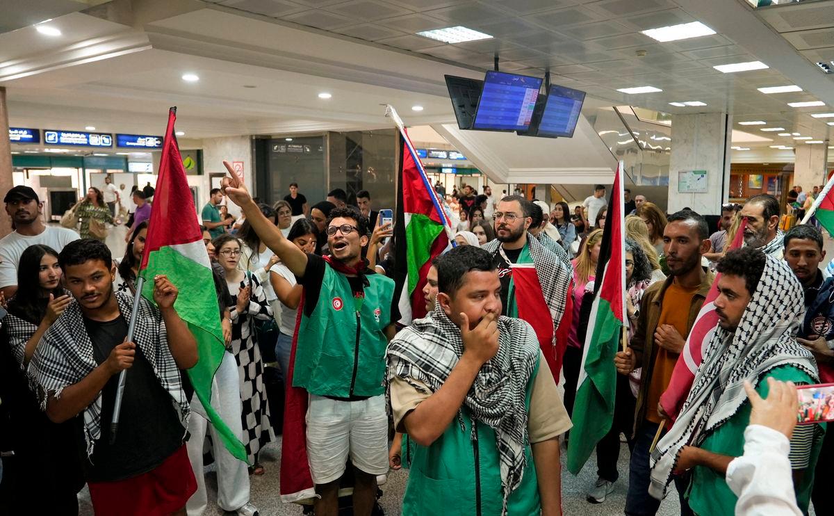 Supporters hold flags and wear keffiyehs as they welcome activists from the Global Sumud flotilla, which was intercepted while aiming to reach Gaza and break Israel’s naval blockade, at the Tunis-Carthage Airport, in Tunis, Tunisia, October 5, 2025. REUTERS/Jihed Abidellaoui
