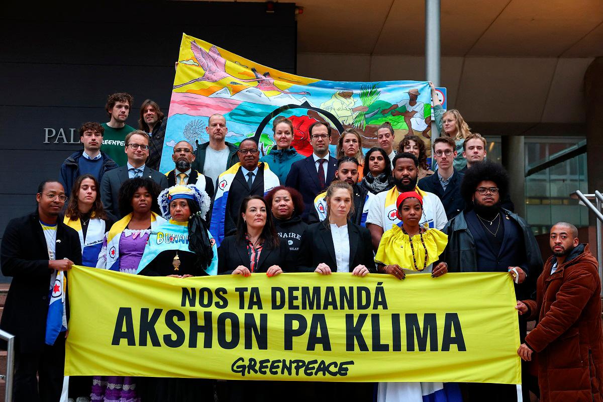 Plaintiffs, the campaign team and director of Greenpeace and people from the diaspora community protest in front of the district court, which hears a case brought by Greenpeace Netherlands and residents of the Dutch-Caribbean island of Bonaire, to force the Netherlands to take more measures to protect the island against the effects of climate change, in The Hague, Netherlands, October 7, 2025. - REUTERS/Piroschka van de Wouw